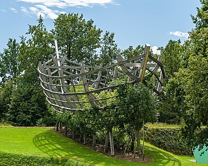 An ark of living trees is currently being created in the Berggarten. For more than a decade, the 25-metre-long wooden scaffolding has served as a temporary support for the plant growth. The wooden scaffolding was removed in 2024.