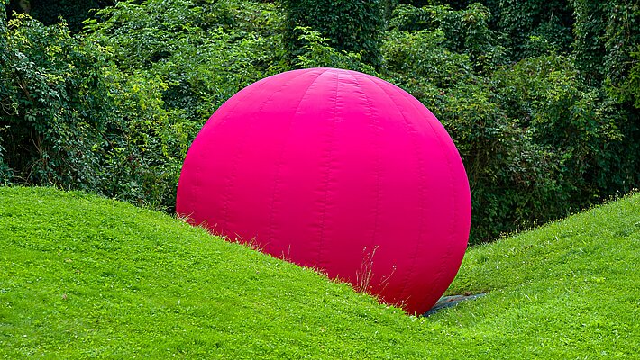 Mitten im Skulpturenpark, hinter dem Berggartencafé. Ein großer sich aufblasender Ball, der mit einem Knall implodiert und in sich zusammenfällt, zählt zu den Lieblingswerken unserer jüngsten Besucher*innen.
