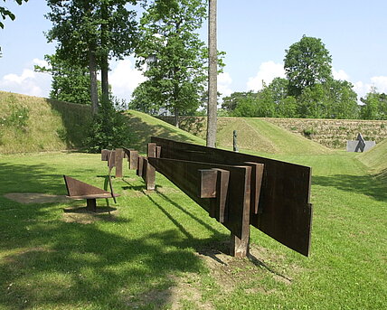 The steel sculpture, which weighs several tons, is ten meters long, two and a half meters wide and one and a half meters high. The work can be read as a relic of an archaic culture as well as a find from the archaeology of the industrial age.