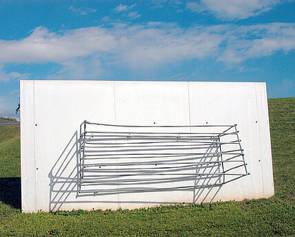 A vertical concrete slab with metal rods that form a basket