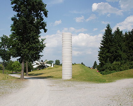 A "pillar" made of precast concrete elements in the entrance area of the sculpture park. The sculpture is deliberately not elaborately or beautifully designed. This keeps the attention on the material itself and allows a sober view of the world.