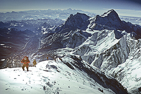 Ein Mann läuft über einen verschneiten Bergkamm.