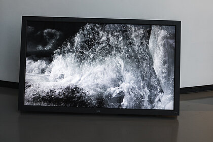 Screen im Foyer auf dem fließendes Wasser zu sehen ist 