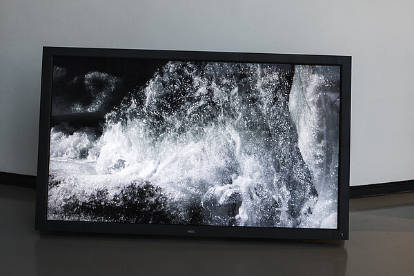 Screen im Foyer auf dem fließendes Wasser zu sehen ist 