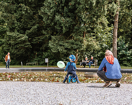 Gäste besichtigen den Seerosenteich im Skulpturenpark. 