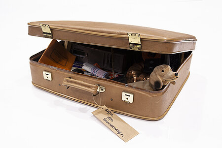 Ein alter Koffer, halb geöffnet, gefüllt mit Objekten
